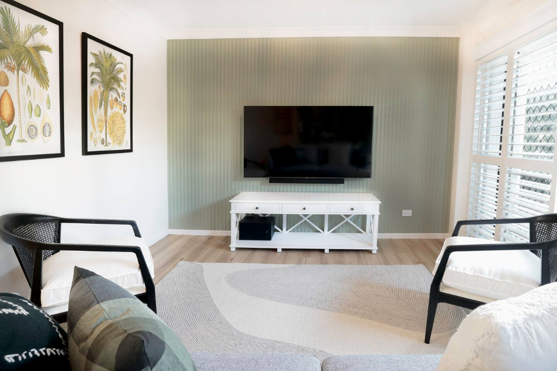 A living room with a flat screen tv on the wall