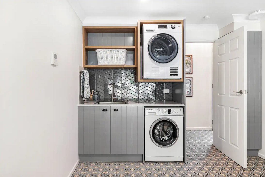 A laundry room with a washer and dryer stacked on top of each other.
