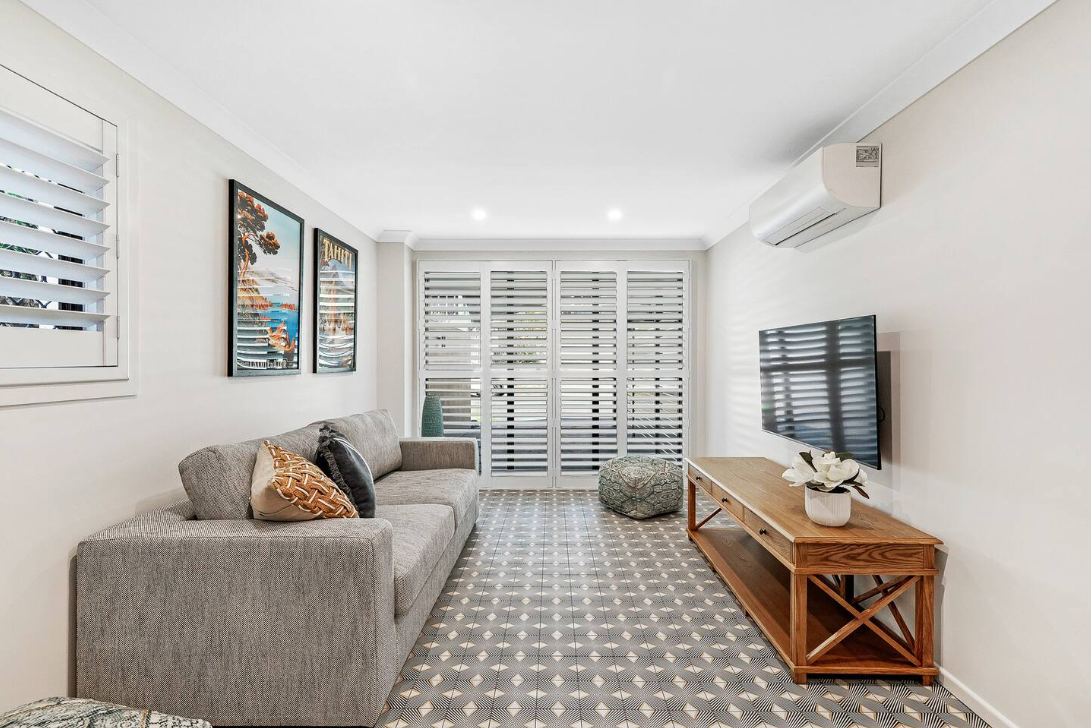 A living room with a couch and a flat screen tv.