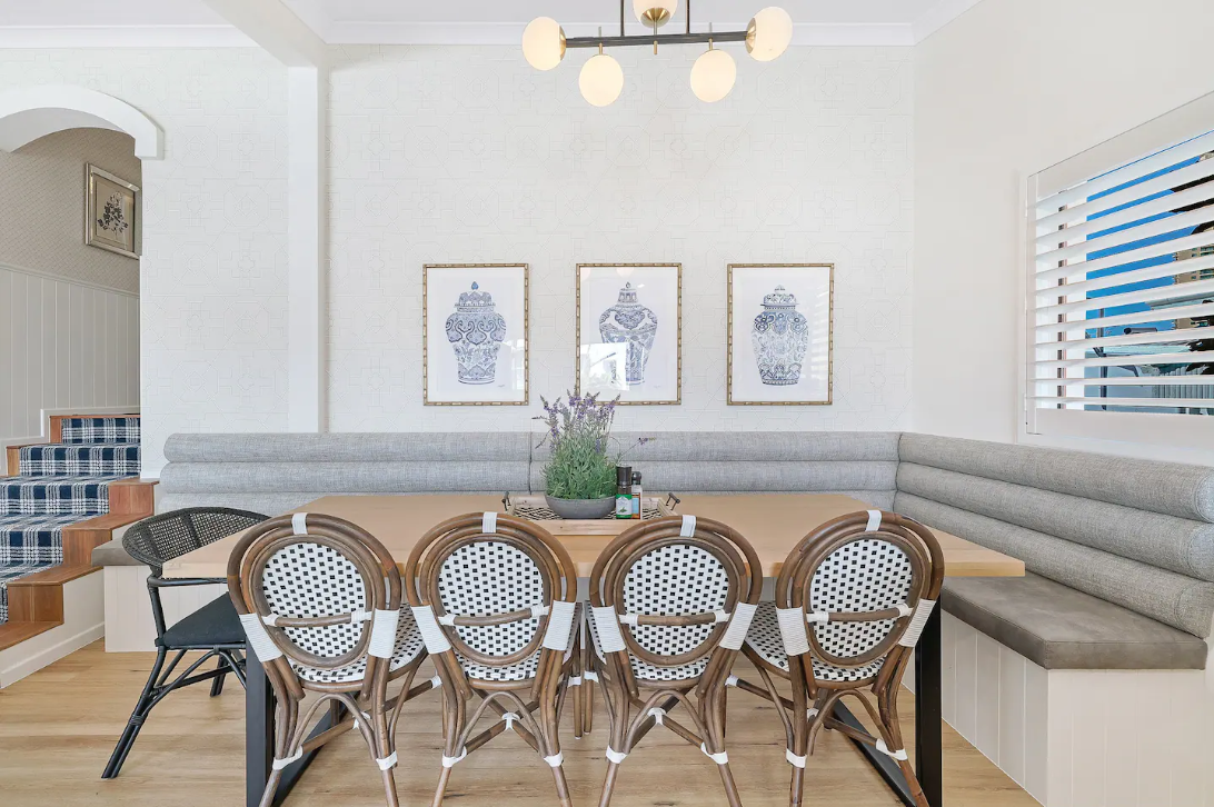 A dining room with a table and chairs and a bench.