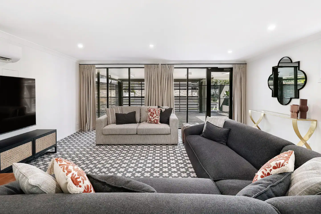 A living room with a large sectional couch and a flat screen tv.