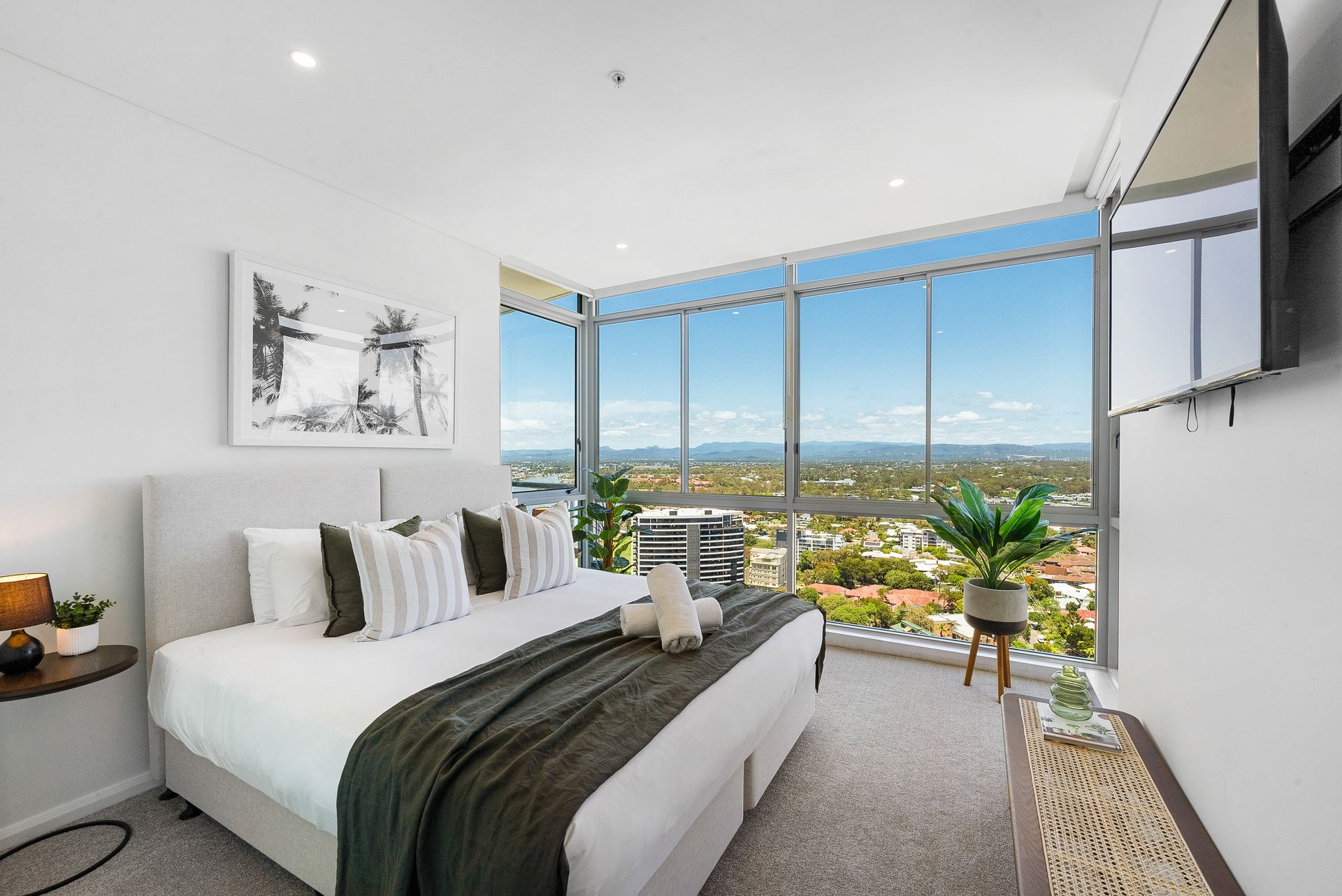 A bedroom with a large bed and a flat screen tv.