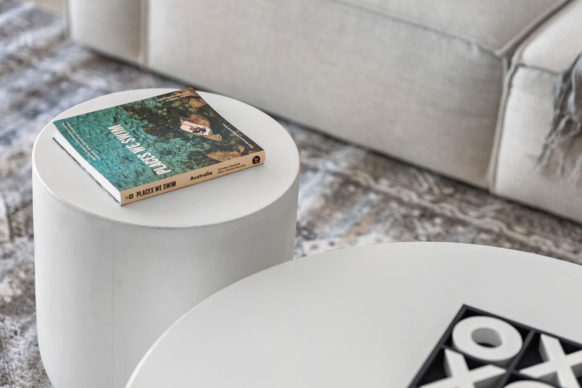 A book is sitting on a small white table in a living room.
