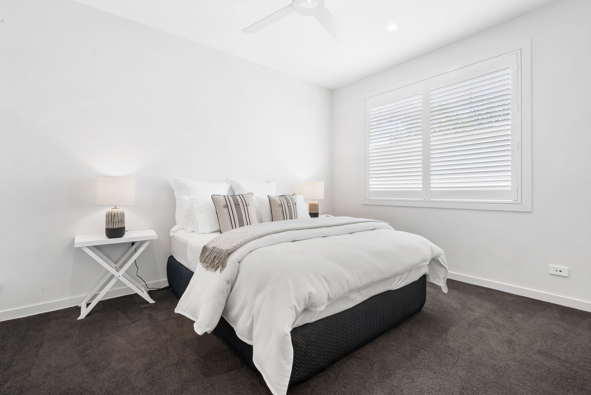 A bedroom with a bed , nightstand and window