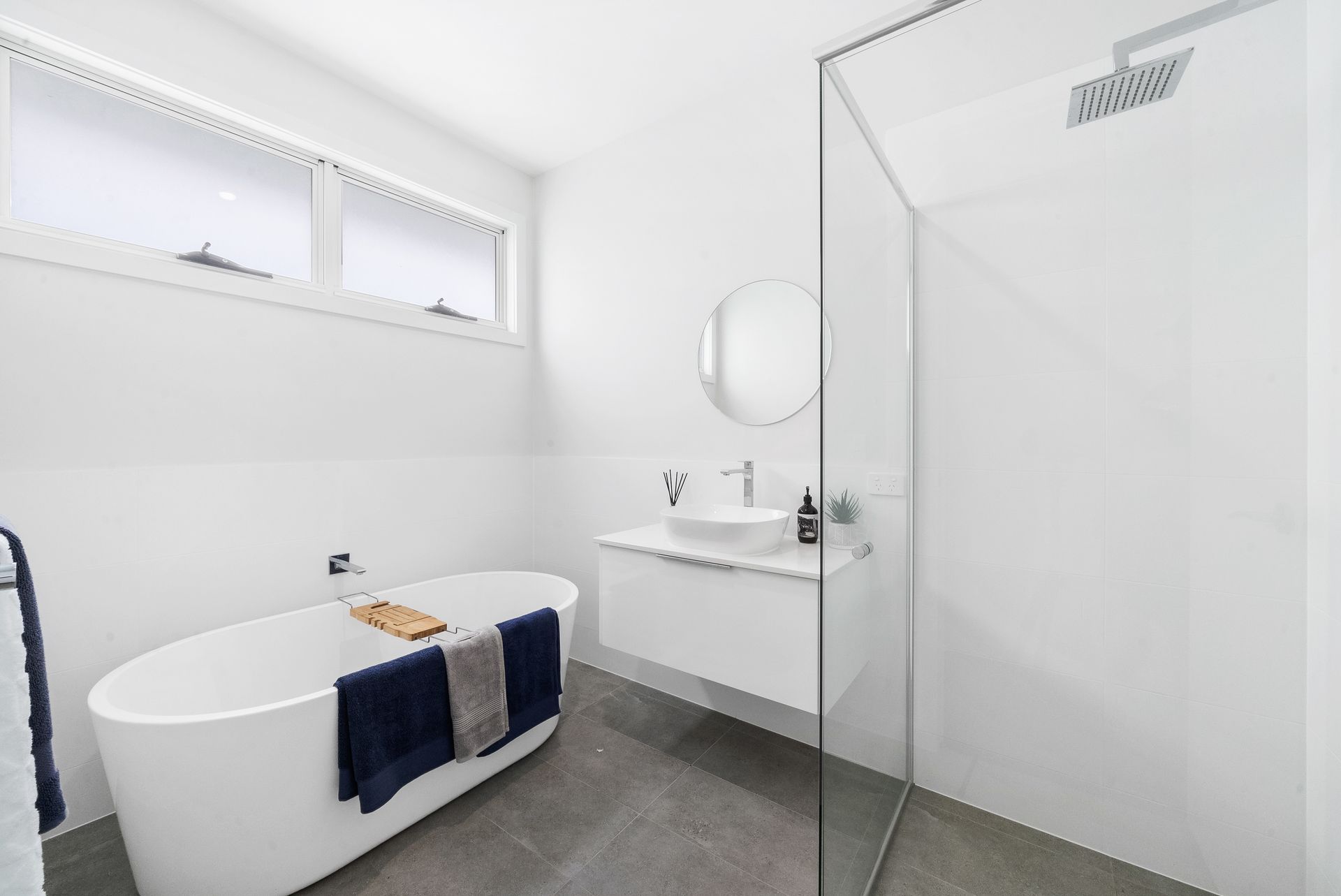 A bathroom with a bathtub , sink , mirror and walk in shower.