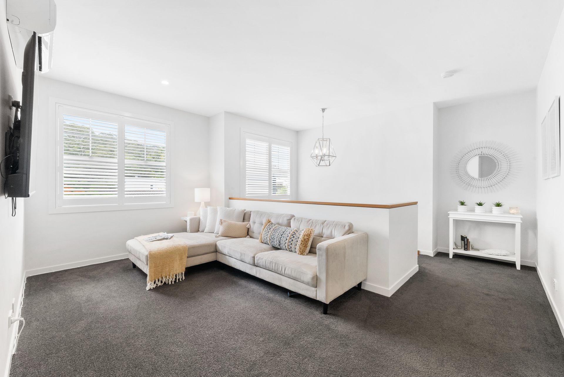 A living room with a couch , television , and mirror.