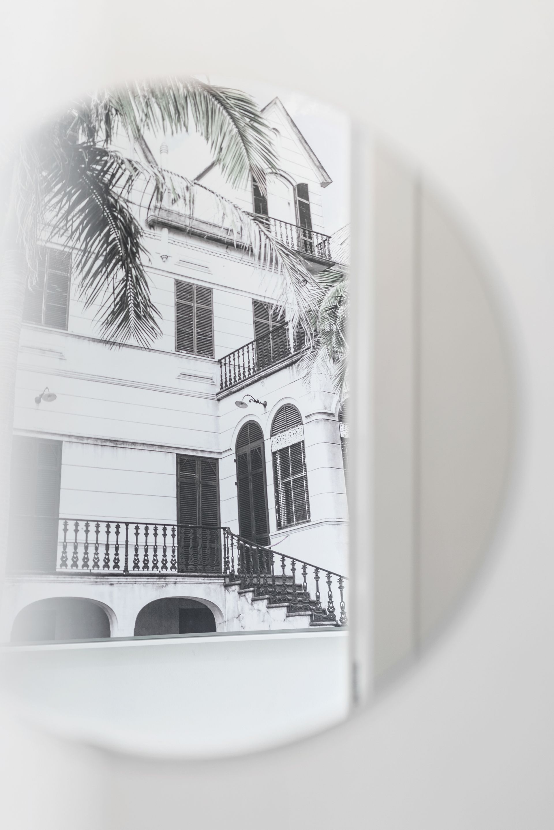 A black and white photo of a house with a balcony and stairs.