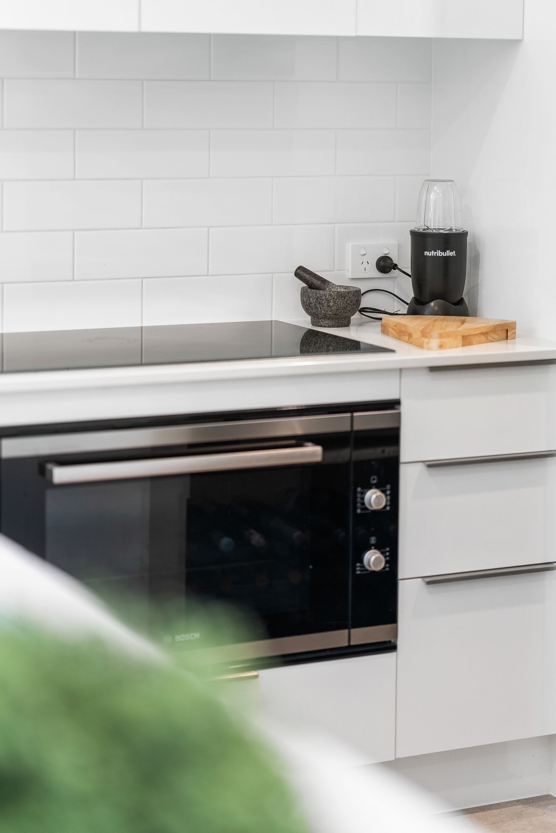 A kitchen with a stove , oven , and cutting board.