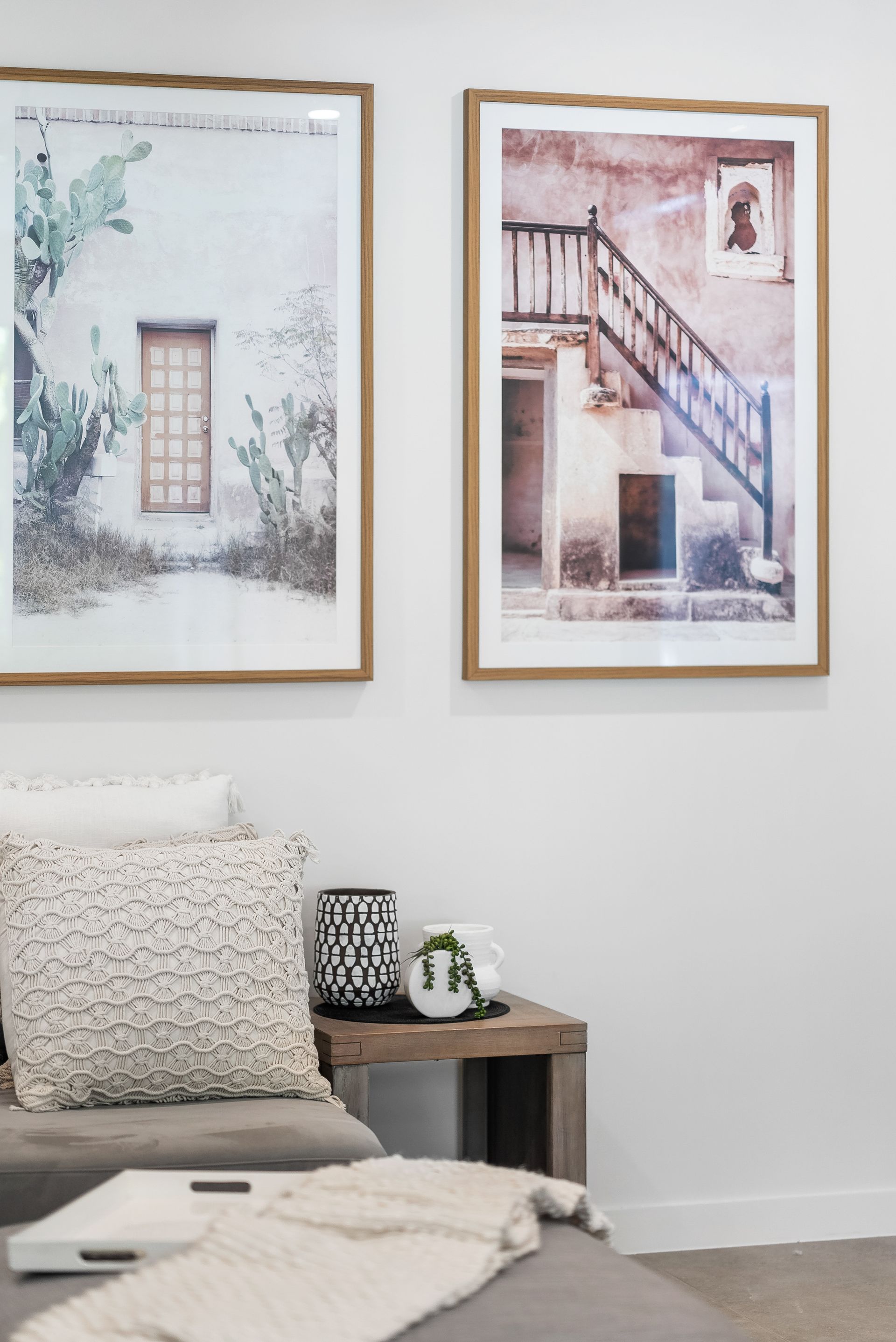 A living room with two framed pictures on the wall above a couch.