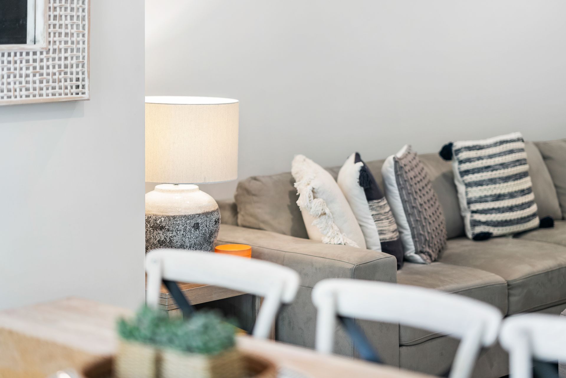 A living room with a couch , chairs , table and lamp.