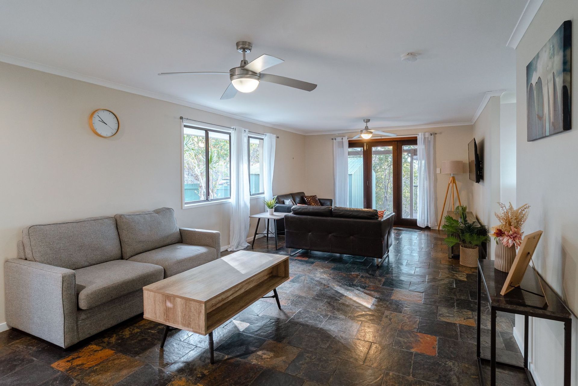 A living room filled with furniture and a ceiling fan.
