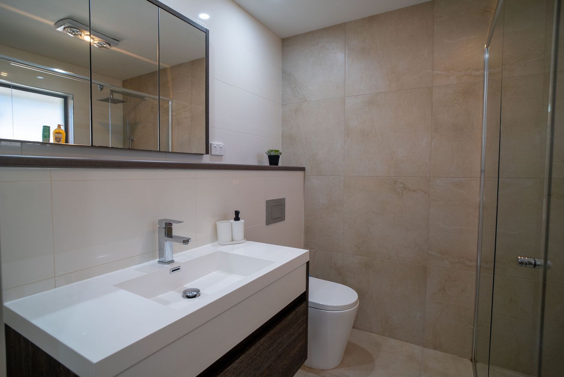 A bathroom with a sink , toilet and shower.