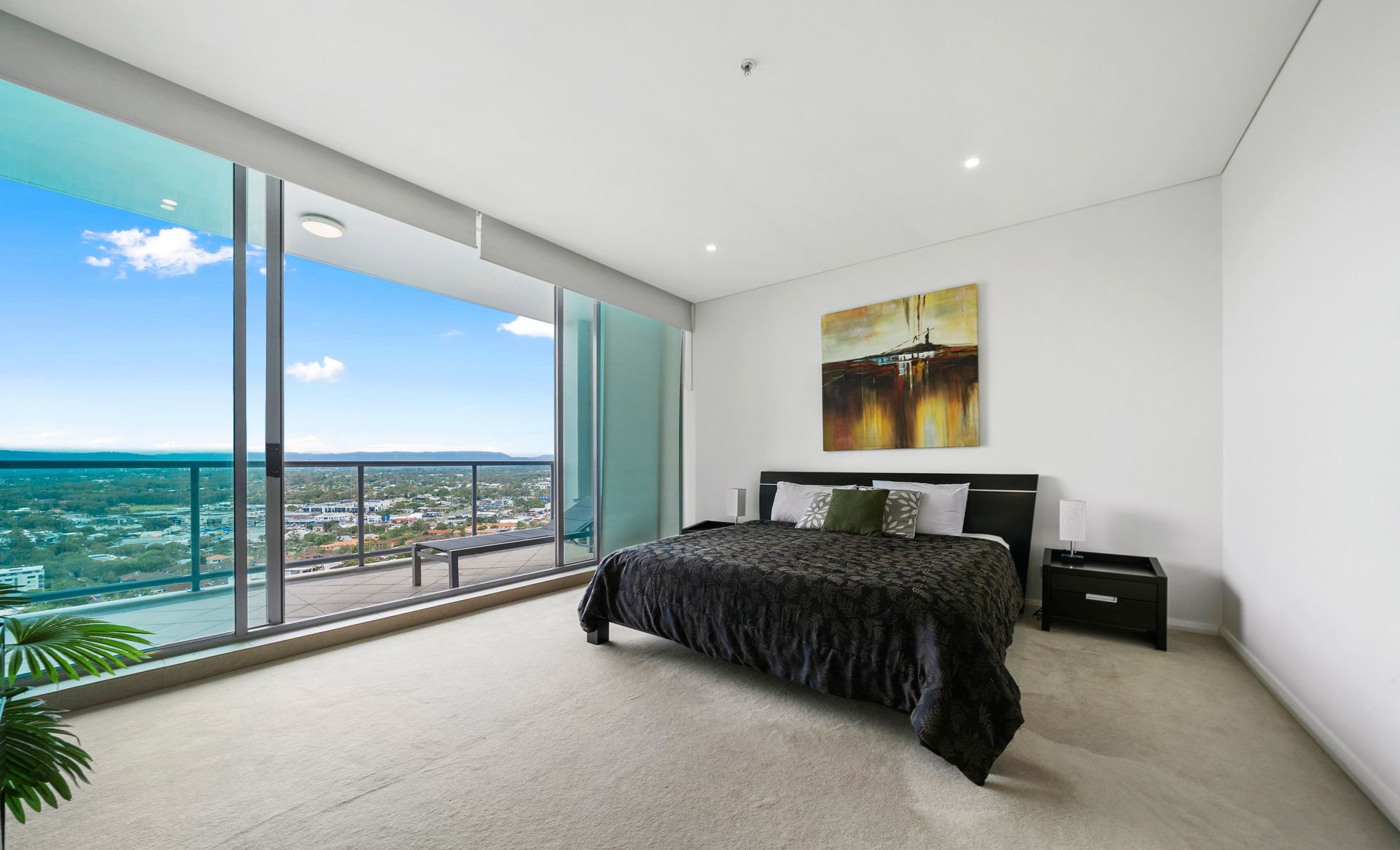 A bedroom with a large bed and a balcony