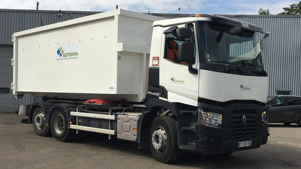 camion blanc transportant une benne vu de face