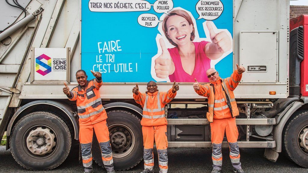 équipe de ripeurs  posant devant un camion benne