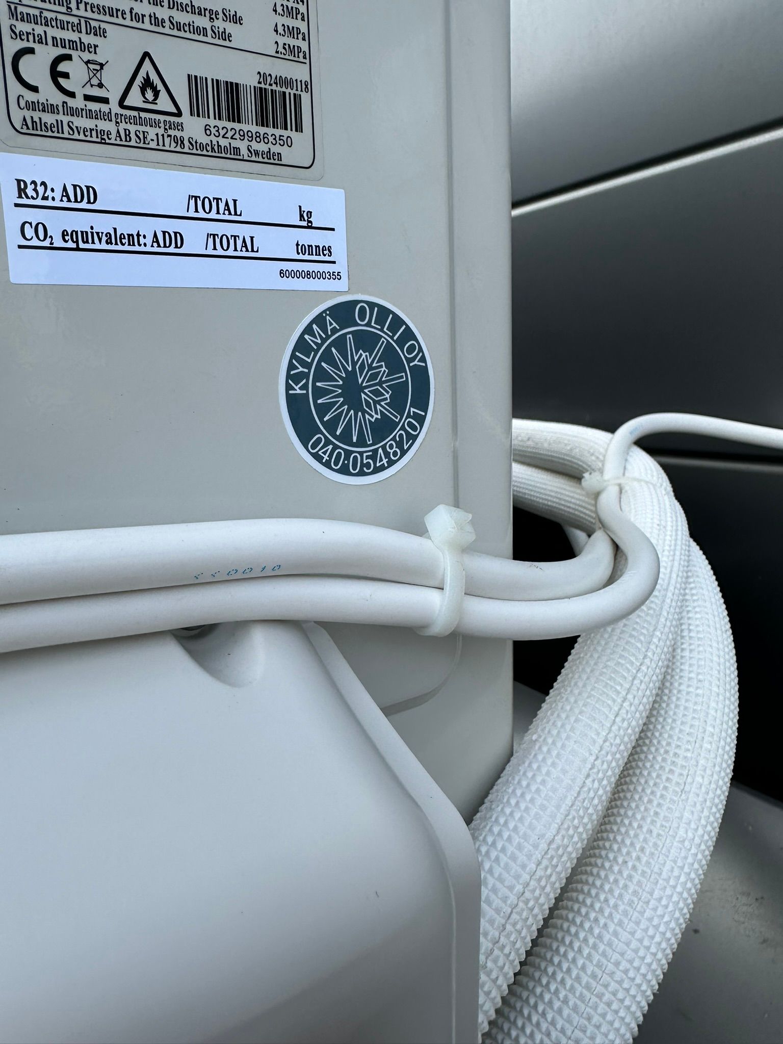 Kylmä Olli Oy Logo ilmälämpöpumpun takana Kustavin kohteessa.