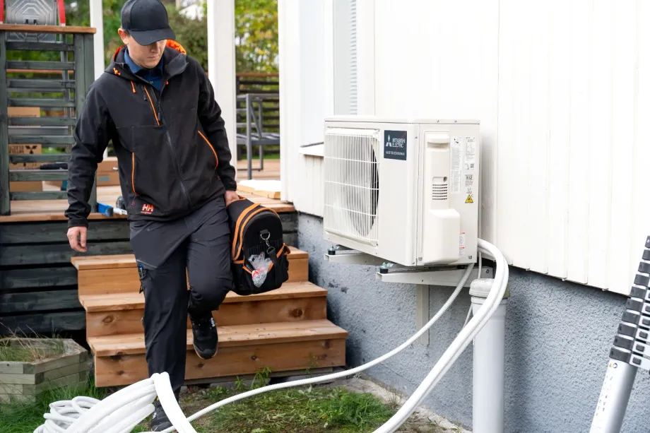 Modernin ilmalämpöpumpun asennus olohuoneen yläkulmaan energiatehokkaan lämmityksen ja viilennyksen varmistamiseksi.