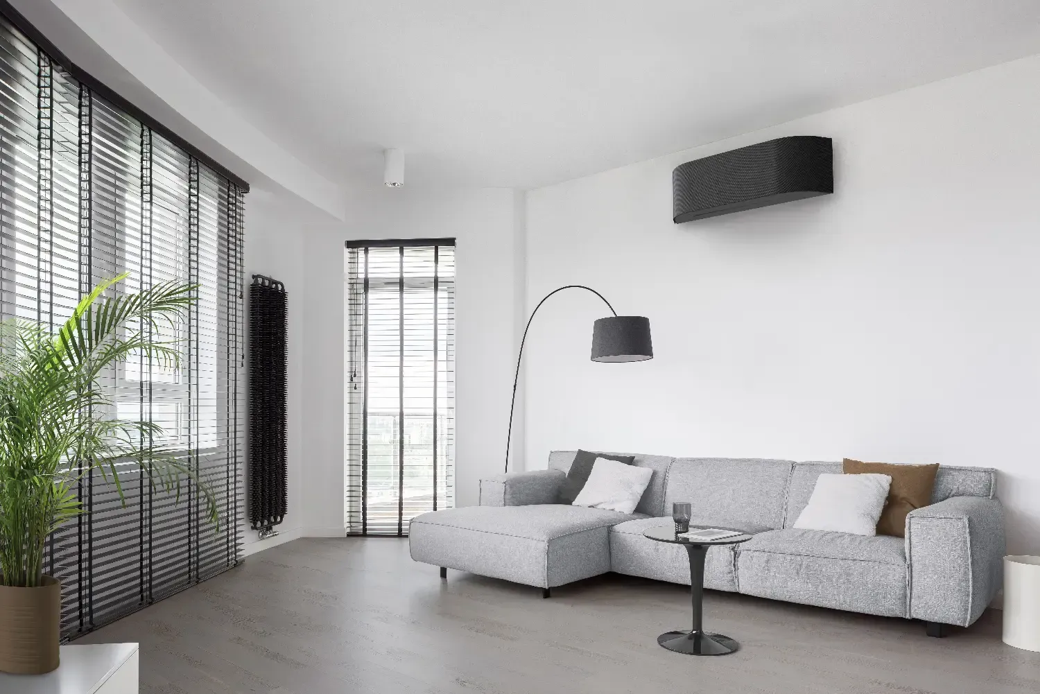 Modernin ilmalämpöpumpun asennus olohuoneen yläkulmaan energiatehokkaan lämmityksen ja viilennyksen varmistamiseksi.