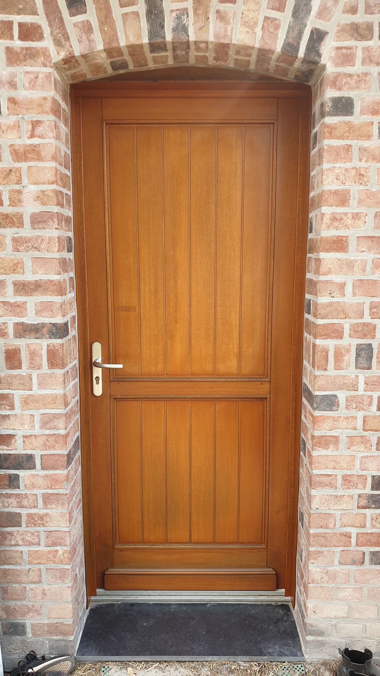 Porte en bois dans une arche en briques.