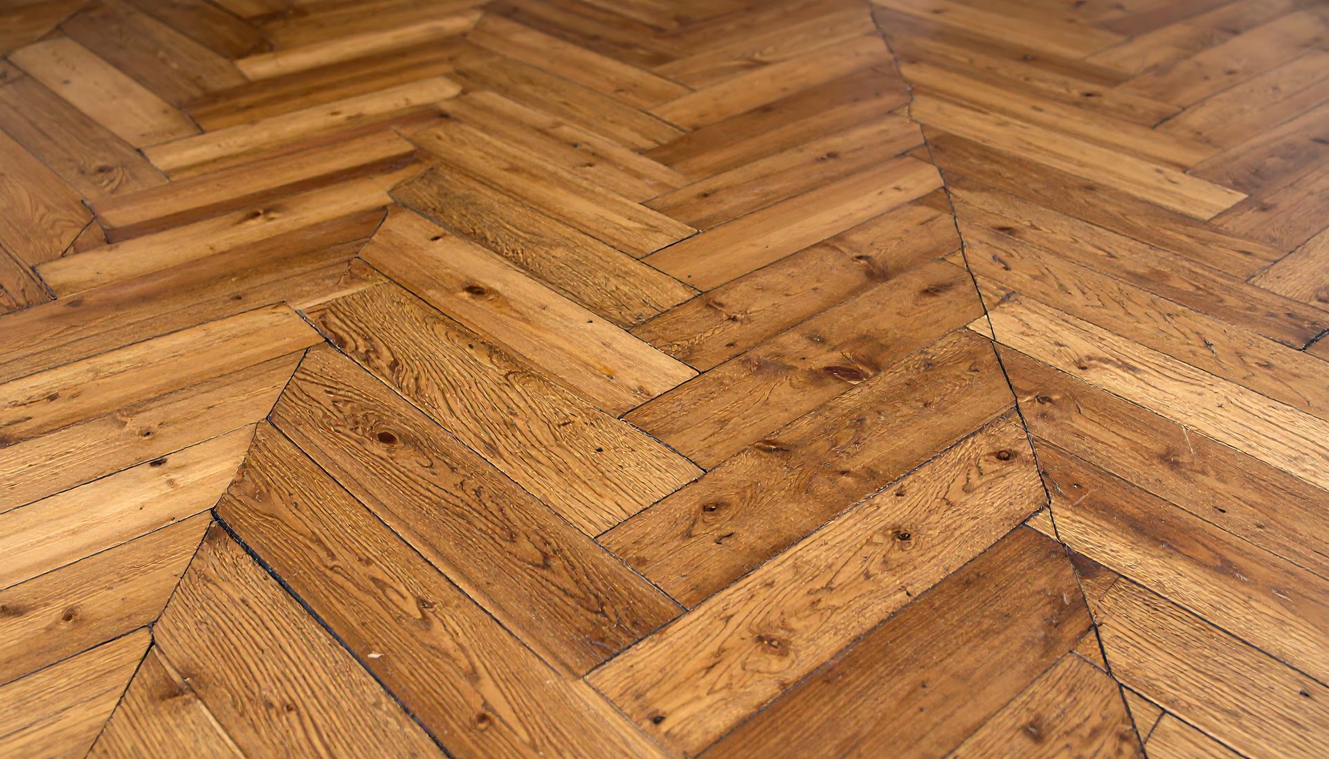 Parquet en bois à chevrons dans des tons de brun.
