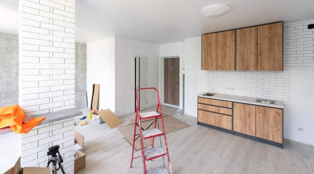Una cocina en construcción con una escalera en el medio de la habitación.