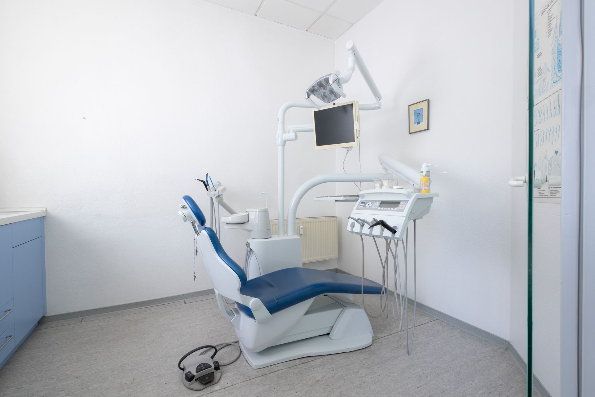 Behandlungszimmer mit einem blauen Zahnarztstuhl