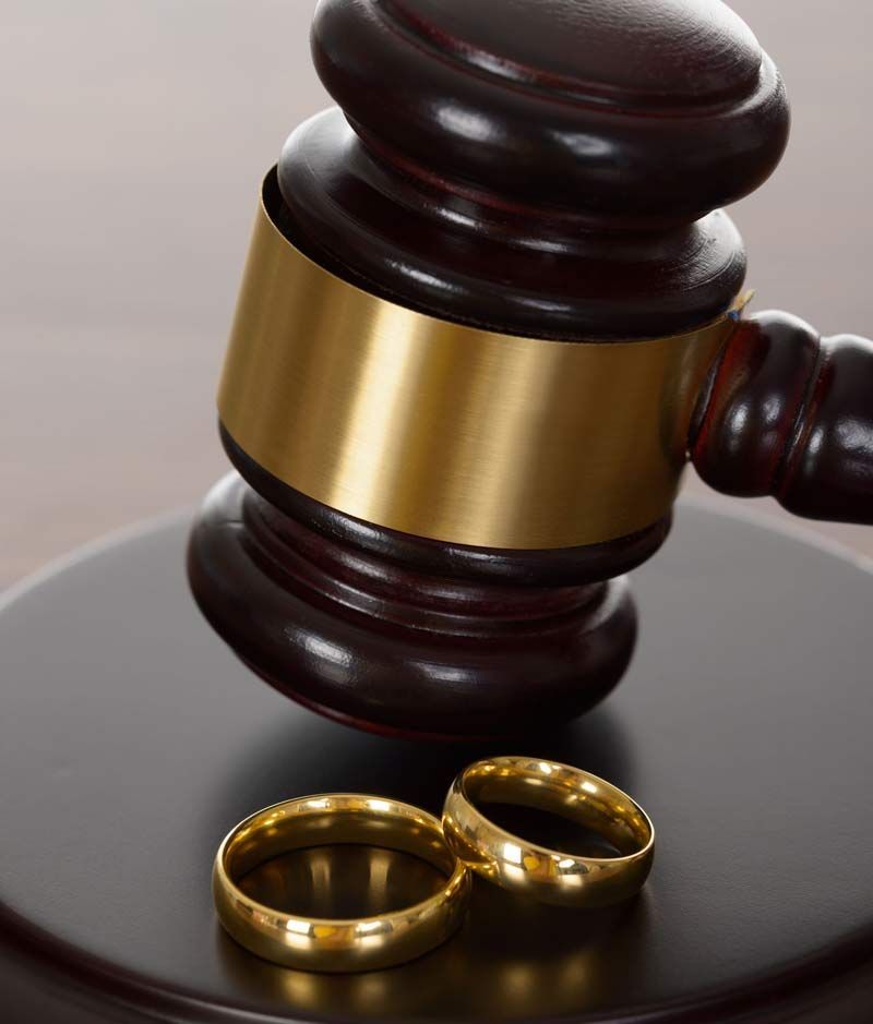 Un par de anillos de boda junto al mazo de un juez.
