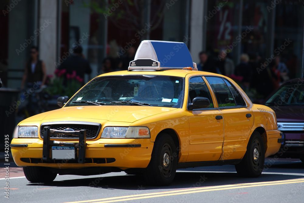 Ein gelbes Taxi mit Dachaufschrift parkt in einer Stadtstrasse.