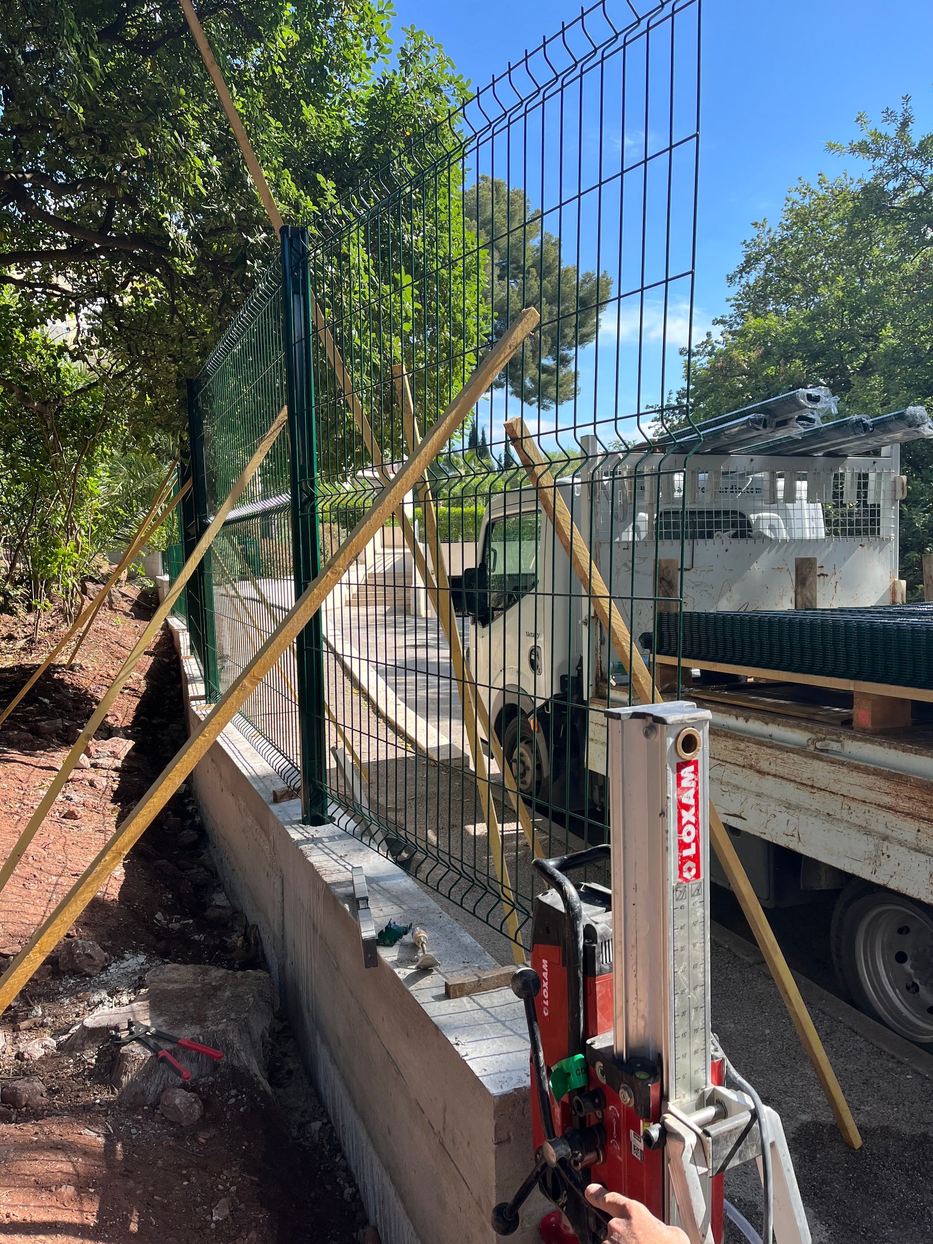 Clôture avec des panneaux rigides en cours d'installation