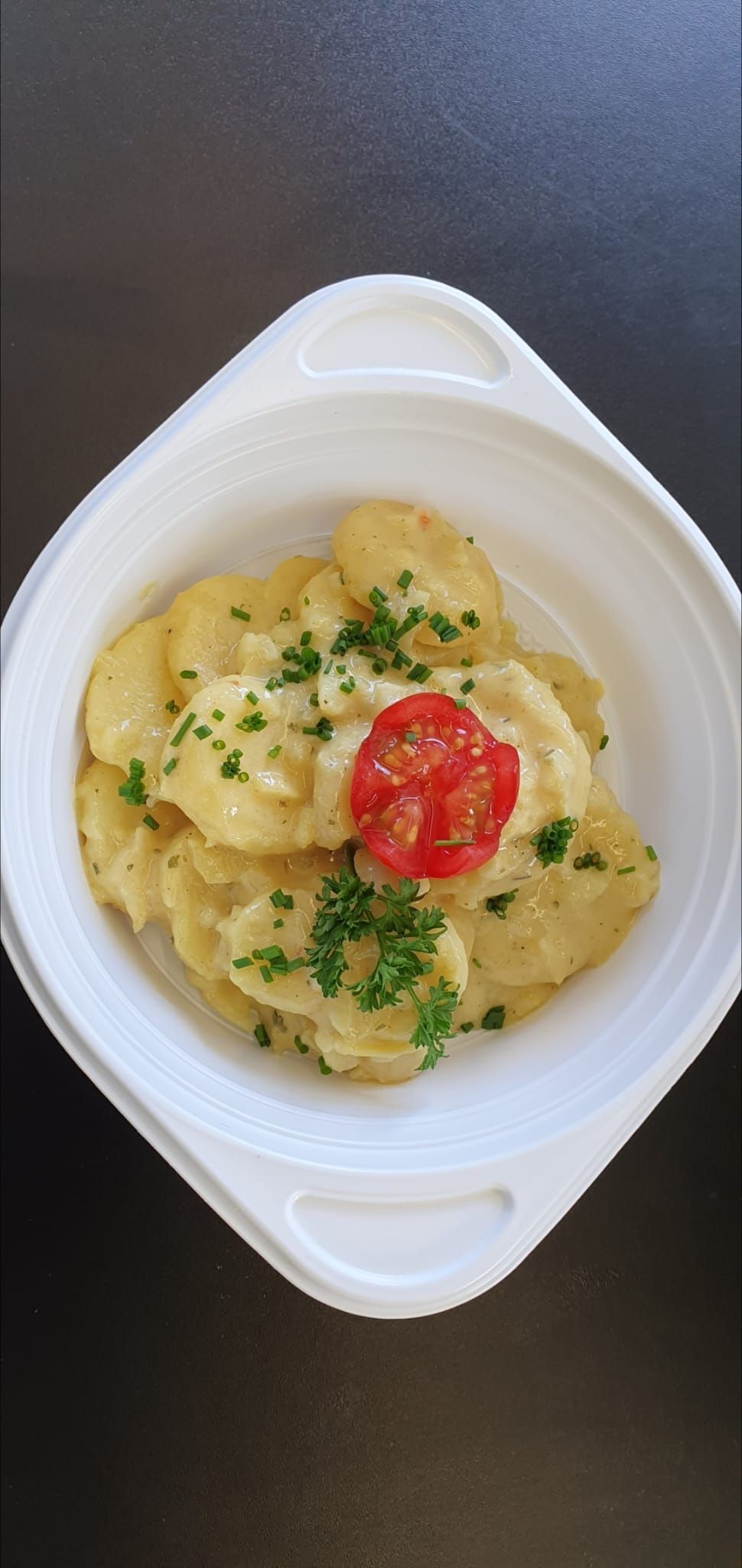 Chef in black gloves garnishes toast with arugula and beets. Various food prep, including figs, surround.