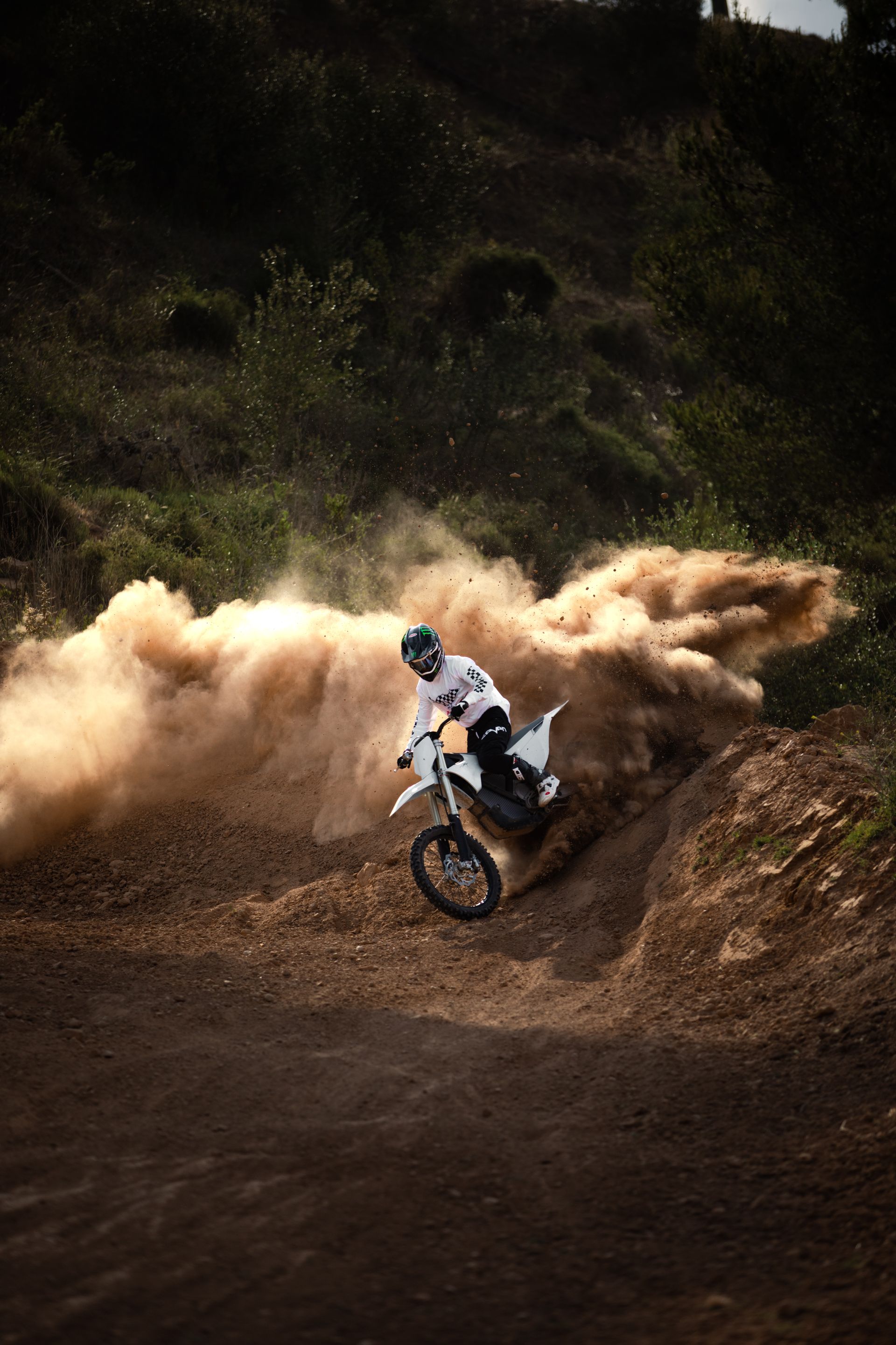 Ein Mann fährt mit einem Dirtbike auf einer unbefestigten Straße.