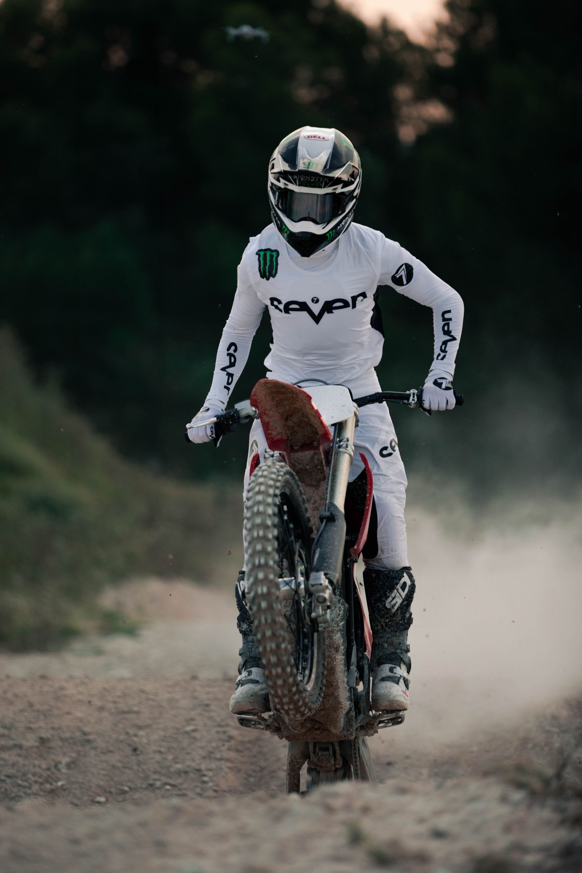 Ein Mann fährt mit einem Dirtbike auf einer unbefestigten Straße.