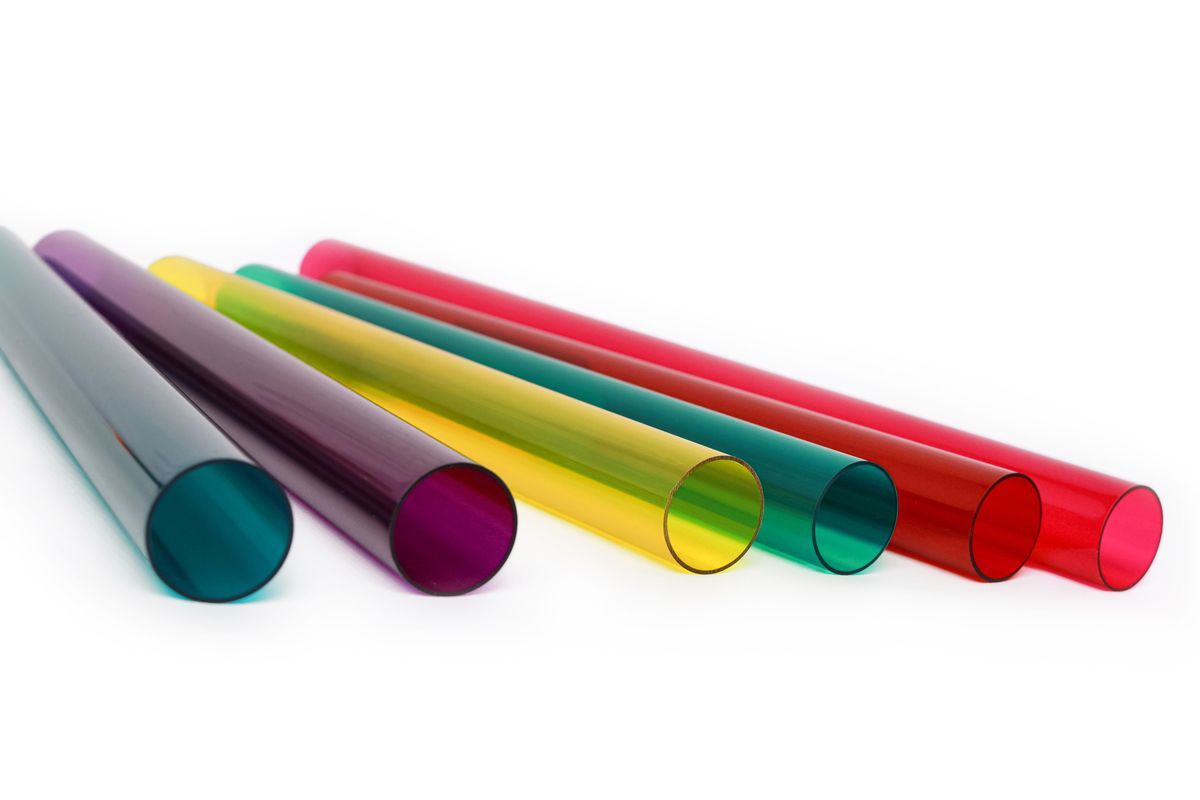 Verschiedenfarbige zylindrische Röhren in unterschiedlichen Größen, angeordnet auf einer Oberfläche mit blauem Farbverlauf.