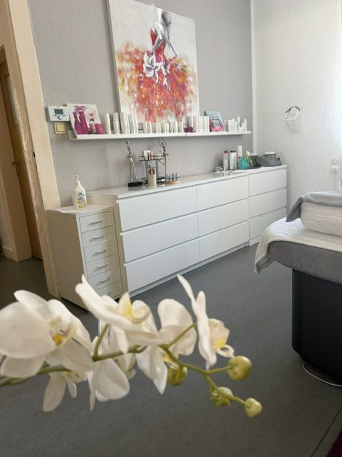 Pflegeprodukte und dekorative Elemente auf einem Regal im Kosmetikstudio