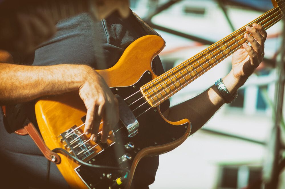 Un hombre está tocando un bajo en el escenario.