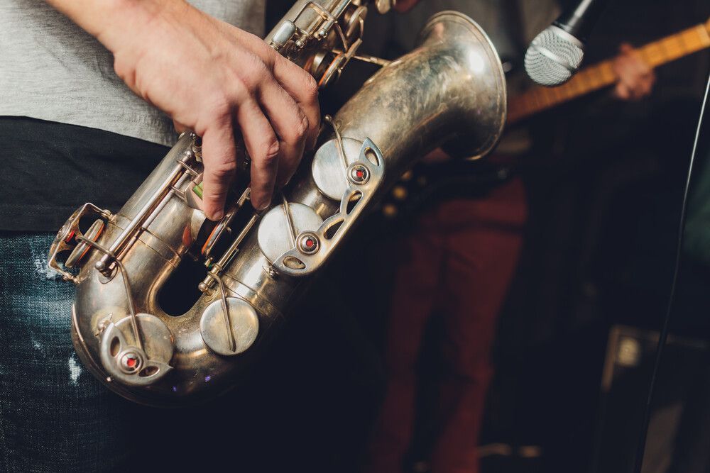 Un hombre está tocando un saxofón en un escenario.