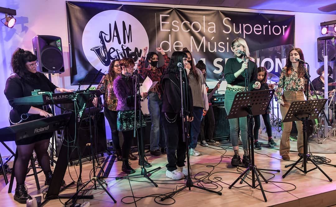 Un grupo de personas está de pie en un escenario tocando instrumentos.