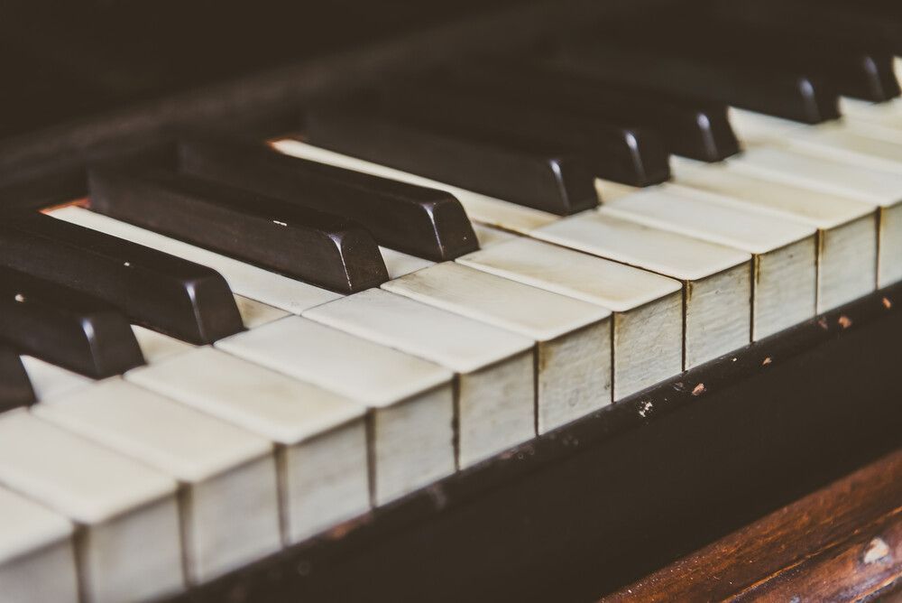 Un primer plano de un teclado de piano con teclas blancas y negras.