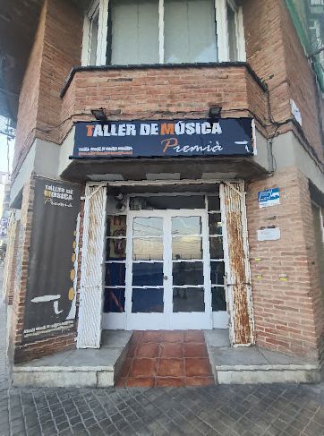 Un edificio de ladrillo con un cartel que dice taller de musica