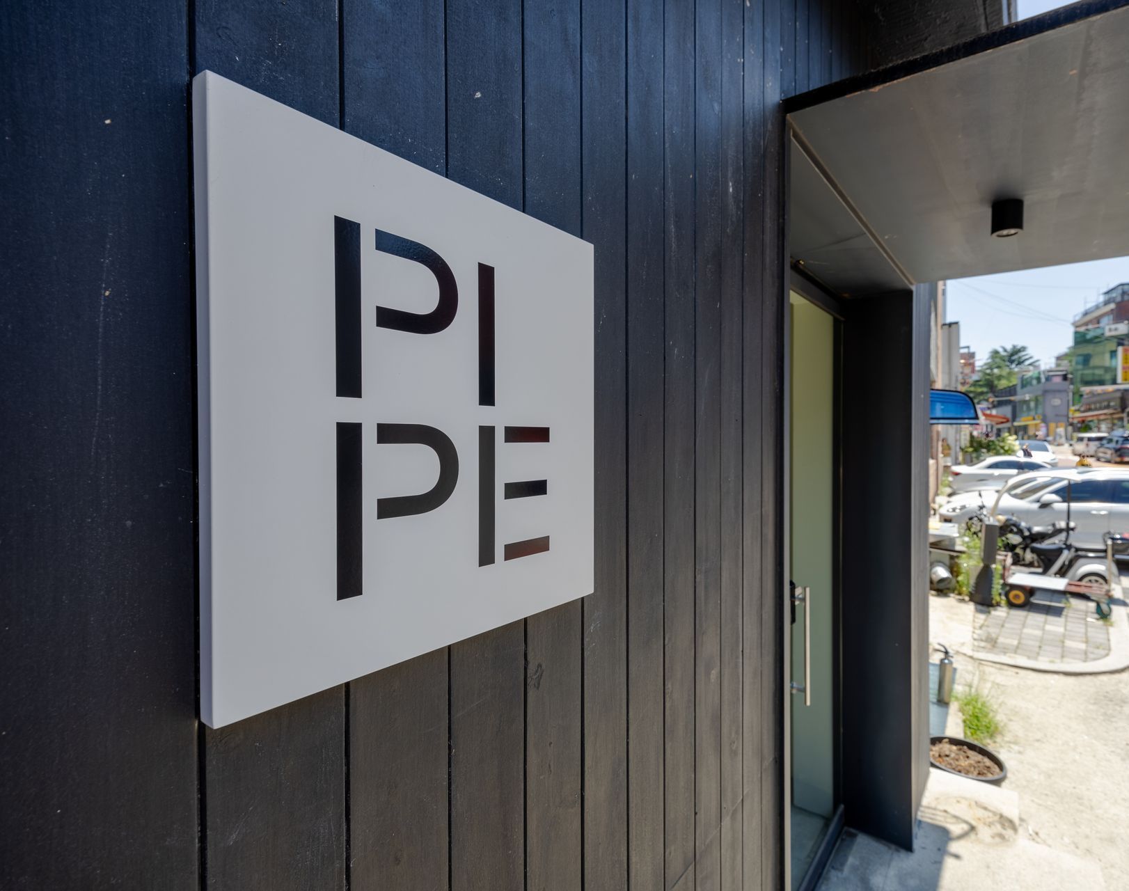 PIPE Hostel. White square sign with 