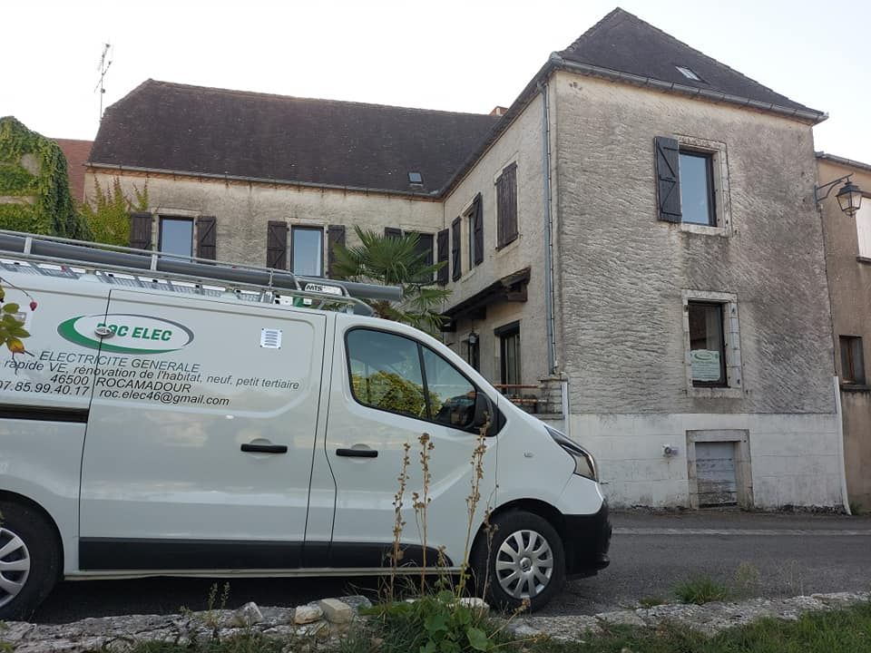 Un utilitaire garé devant une grande maison.
