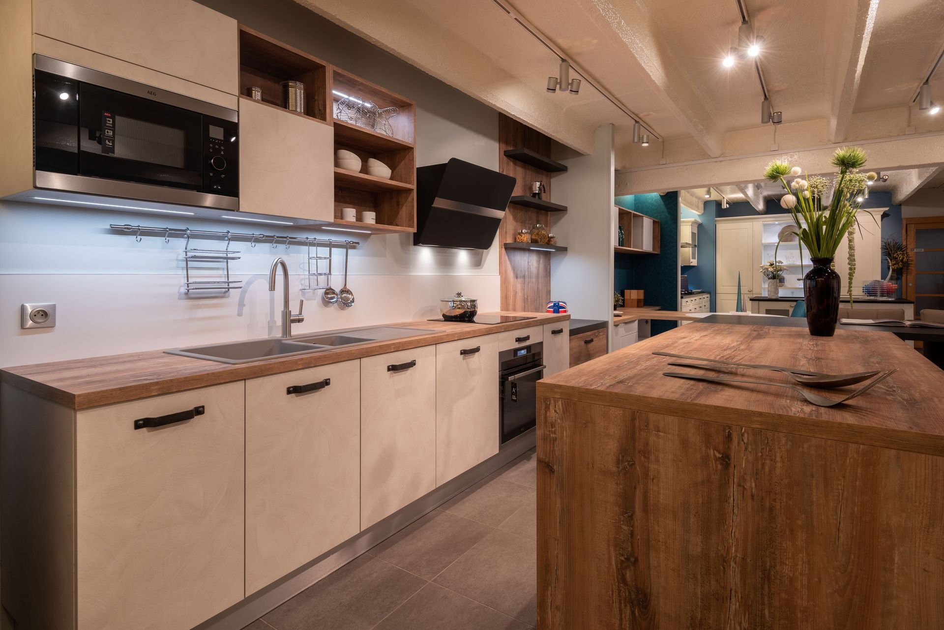 Cuisine moderne avec îlot en bois, placards clairs, et électroménager en inox.