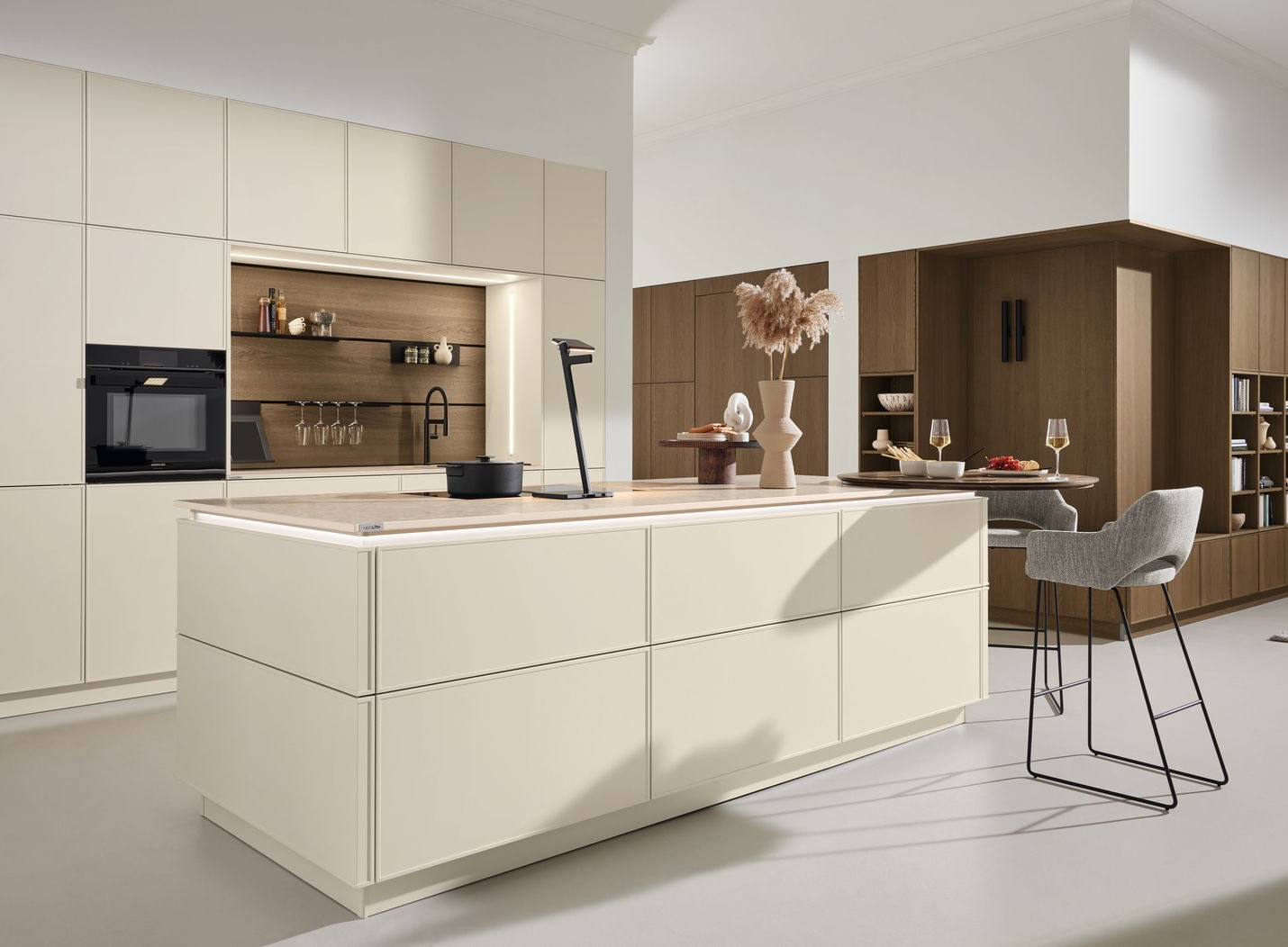 Cuisine moderne et minimaliste avec armoires couleur crème et îlot central.