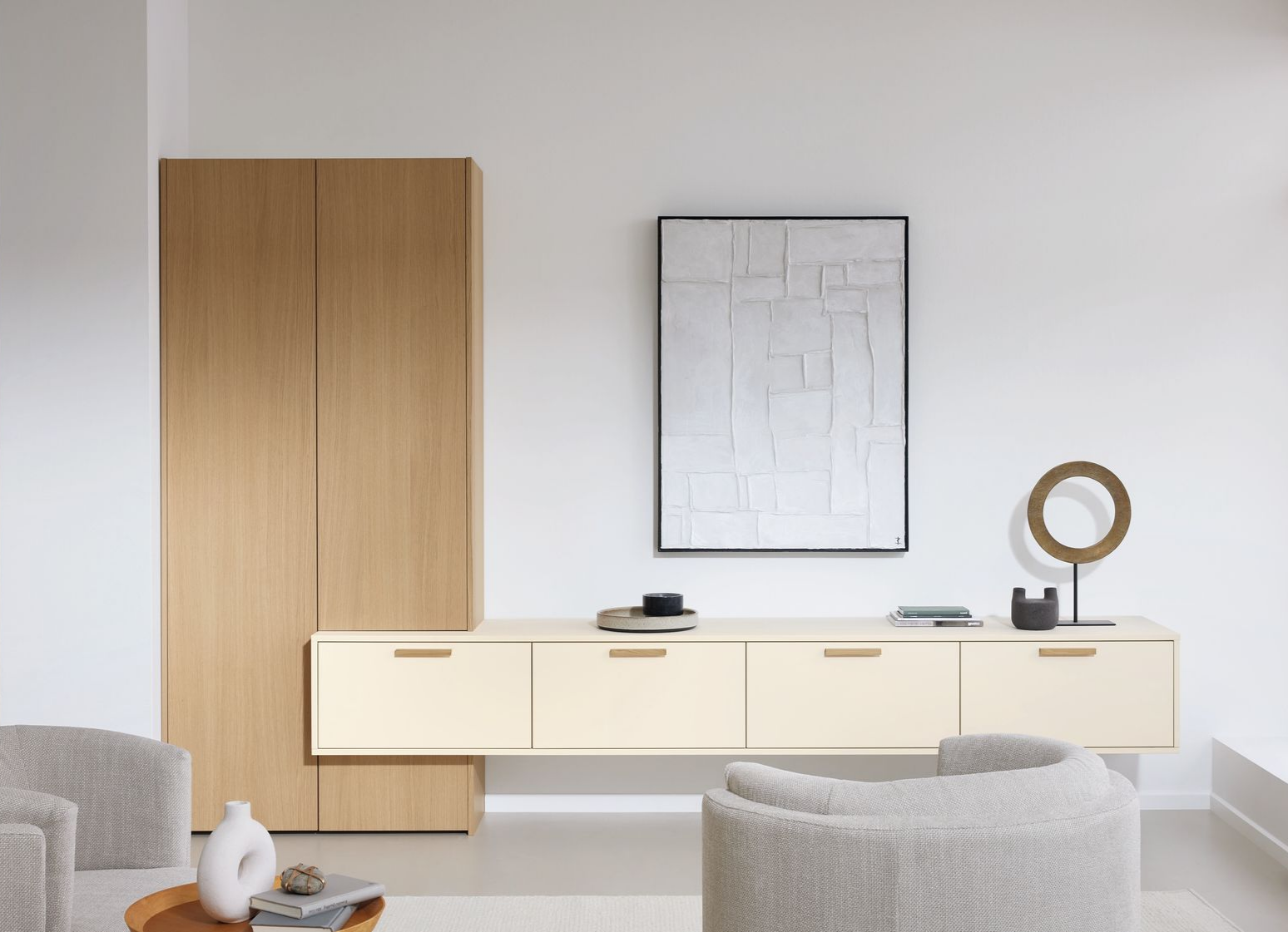 Salon minimaliste avec buffet crème, tableau et armoire en bois.