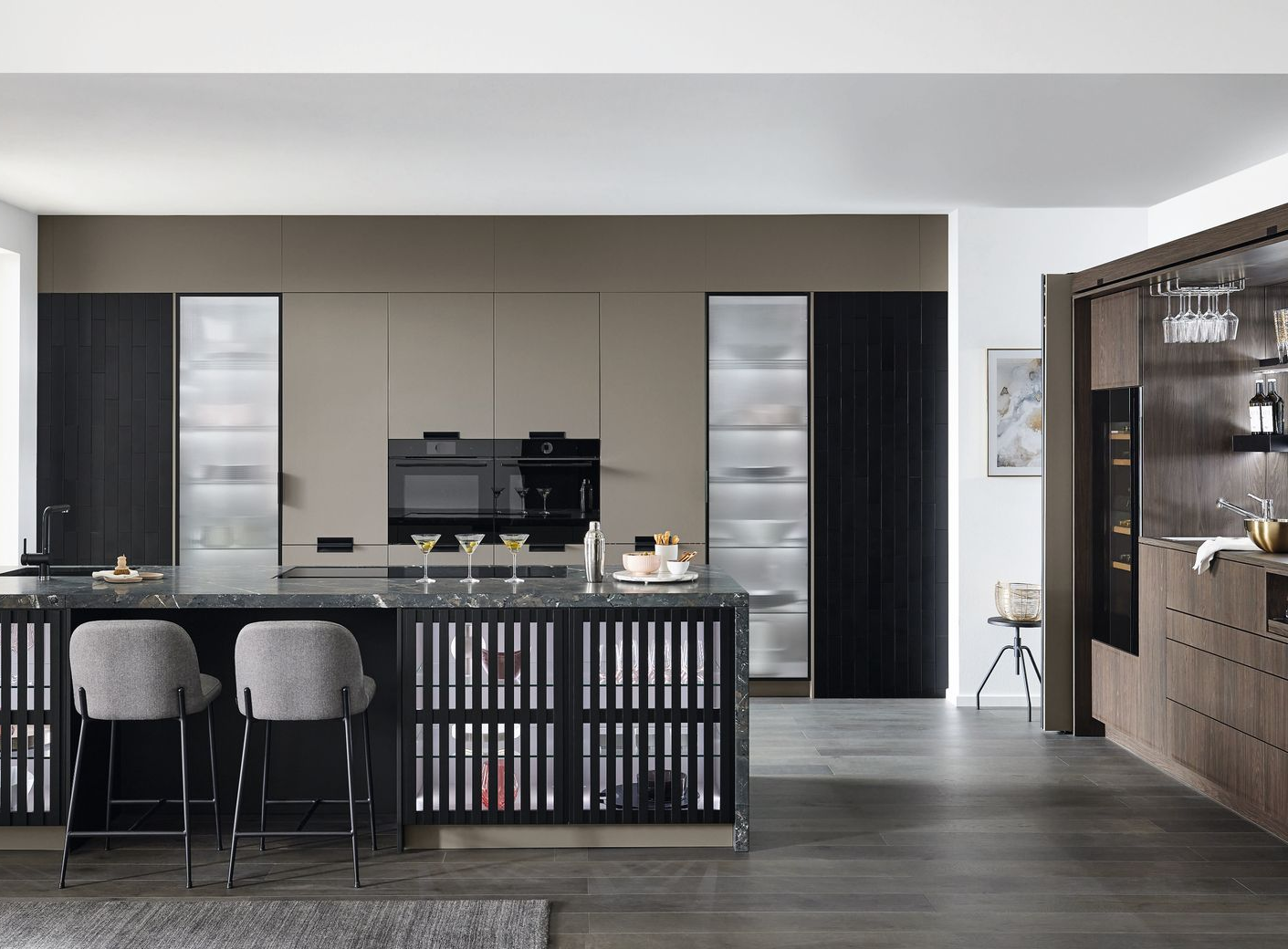 Cuisine avec armoires foncées, îlot central et appareils électroménagers.