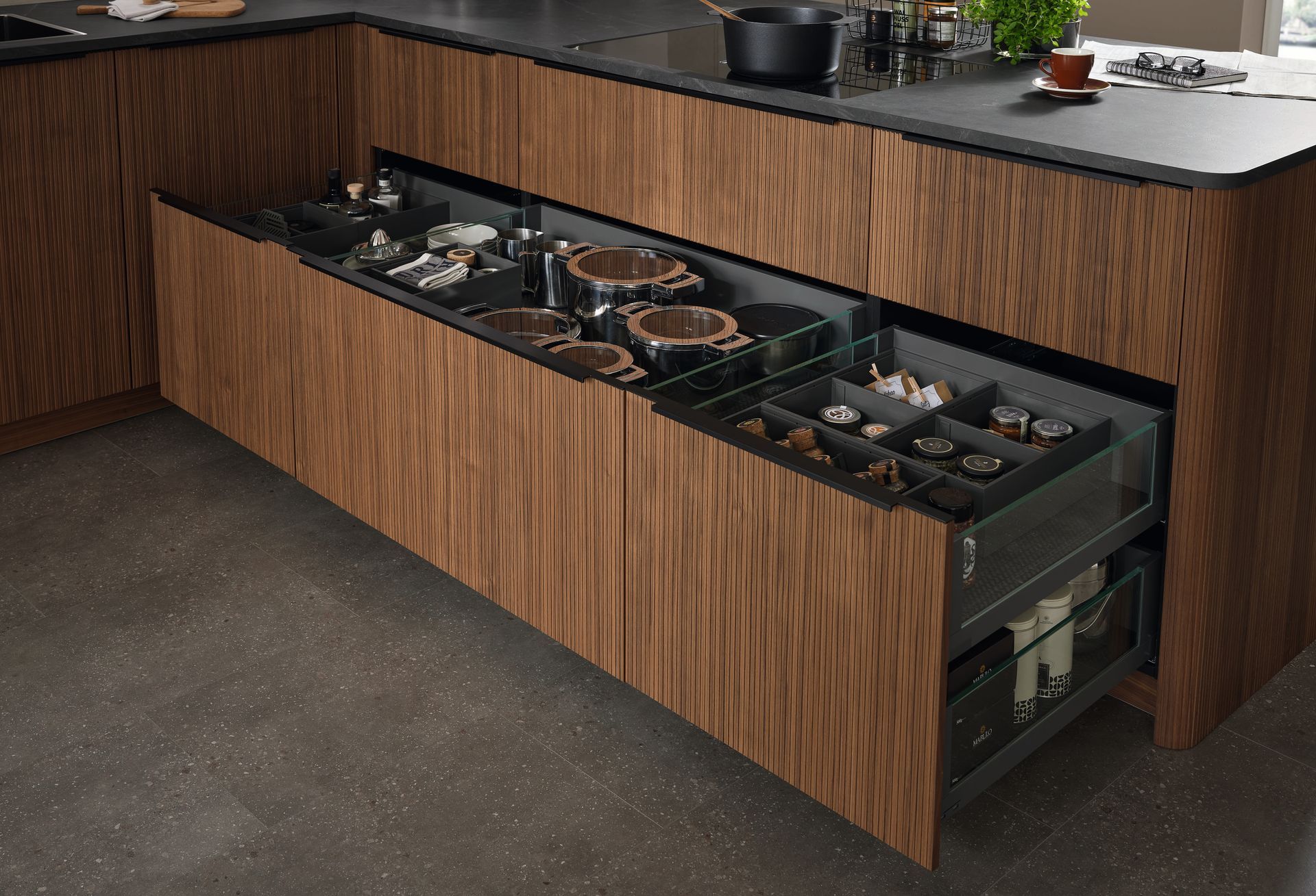 Îlot de cuisine moderne avec un tiroir coulissant contenant les ustensiles de cuisine et les casseroles.
