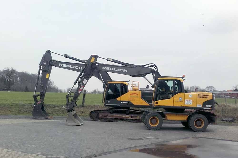 Gelb-schwarzer Bagger auf Rädern; Erdarbeiten im Gange.