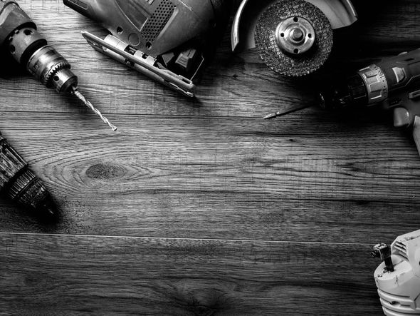 Des outils disposés sur un établi en bois autour d'un espace central vide.