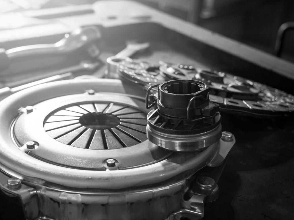 Gros plan sur un disque d'embrayage métallique et des pièces automobiles dans un atelier.