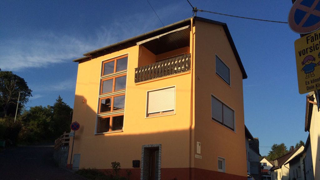 Ein gelbes Haus mit einem Balkon und einem Schild mit der Aufschrift „Parken verboten“